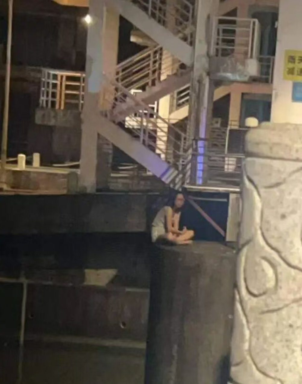 女子坐在桥墩上，情况紧急